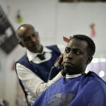 A hairdresser gives a haircut at Abdulqadir Abdul's newly opened barber shop in Mogadishu, Somalia, on January 20. AU UN IST PHOTO / Tobin Jones