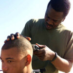 US Marine Corps (USMC) Lance Corporal (LCPL) Gary Hodg, receives a haircut from Sergeant (SGT) Korey Evens, while deployed at Camp Ripper, Kuwait, during Operation ENDURING FREEDOM. Both Marines are assigned to the 7th Marine Regiment Headquarters (HQ) Communications (COM) Company.